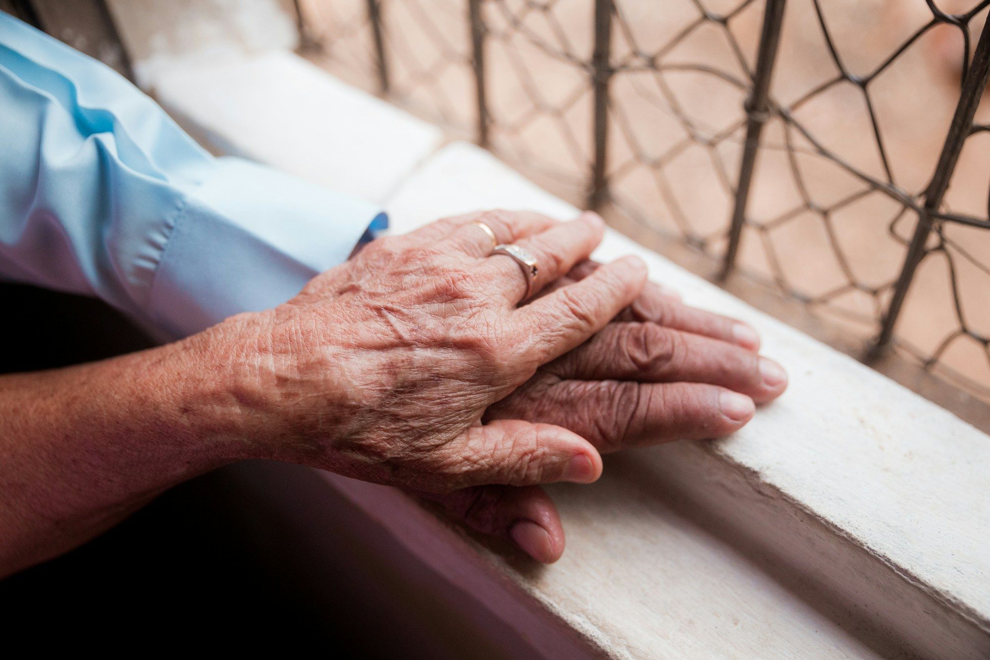 Eine jüngere Hand liegt auf der Hand einer älteren Person